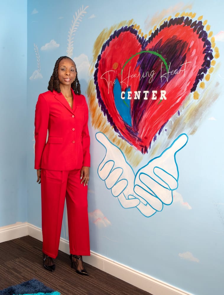 Kendra M. King standing beside The Healing Heart Center mural